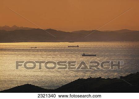 Stock Image - Shipping In The Straits Of Gibraltar With A View Spain (Europe) In Foreground And Morocco (North Africa) In The Background; Spain. Fotosearch