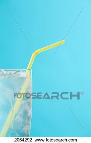 Stock Image - Side Portion Of Clear Glass Of Water With Yellow Drinking Straw. Fotosearch