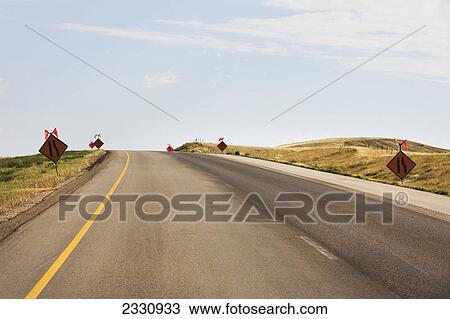 Stock Image - Signs warning of construction on the trans-canada highway; Saskatchewan canada. Fotosearch