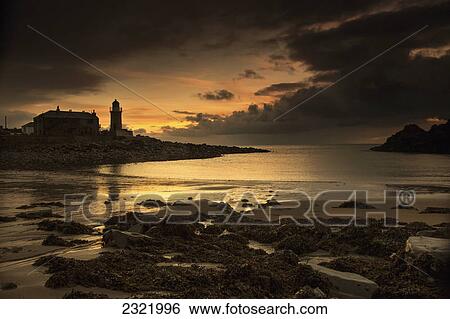 Stock Photograph - Silhouette Of A Lighthouse Along The Coast At Sunset; Portpatrick Dumfries And Galloway Scotland. Fotosearch