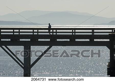 Silhouette Of A Man Walking Along A Pier, Sidney, Bc, Canada View Large Photo Image Stock Image - Silhouette Of A Man Walking Along A Pier, Sidney, Bc, Canada. Fotosearch