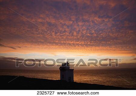Stock Photo - Silhouette of black head lighthouse at sunset near ballyvaghan; County clare ireland. Fotosearch