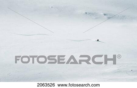 Stock Photograph - Skier Dwarfed By Mountain, British Columbia, Rogers Pass. Fotosearch