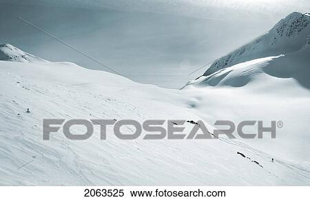 Stock Photography - Skier Dwarfed By Mountain; Canada, British Columbia, Rogers Pass. Fotosearch