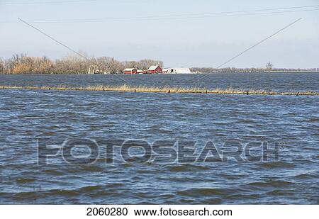Stock Image - Spring Floodwaters Of The Red River Make An Island Of A Framyard, Rural Manitoba. Fotosearch