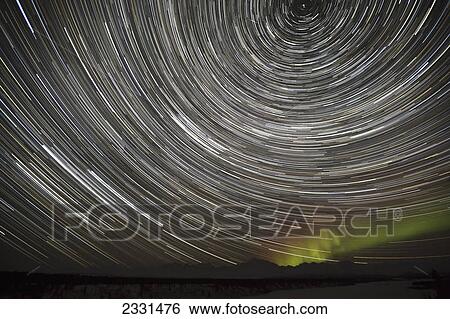 Stock Photograph - Star trails and northern lights above denali (mt. mckinley) and the alaska range from denali viewpoint south along the parks highway denali state park; Alaska united states of america. Fotosearch