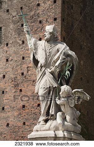 Statue Holding A Cross In Front Of A Brick Wall Of The Sforza Castle; Milano Lombardia Italy View Large Photo Image Stock Photo - Statue Holding A Cross In Front Of A Brick Wall Of The Sforza Castle; Milano Lombardia Italy. Fotosearch
