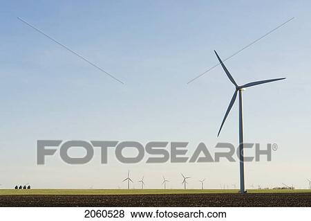 Stock Photo - Steel Graineries Dwarfed By Array Of Wind Turbines. Fotosearch
