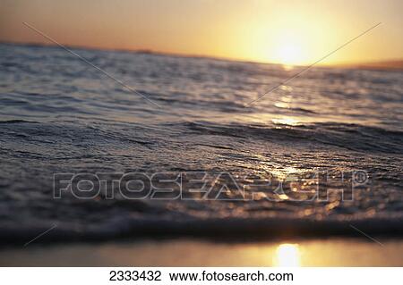 Stock Image - Sunlight reflecting off the water at sunset; Honolulu hawaii united states of america. Fotosearch