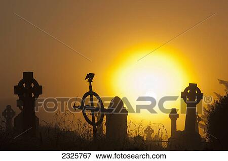 Stock Photo - Sunrise at aghadoe heights graveyard with silhouetted tombstones; Killarney county kerry ireland. Fotosearch