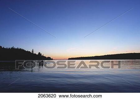Stock Image - Sunset At Clear Lake; Canada, Manitoba, Riding Mountain National Park. Fotosearch