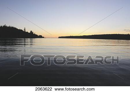 Stock Image - Sunset At Clear Lake; Canada, Manitoba, Riding Mountain National Park. Fotosearch
