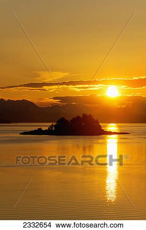 Picture - Sunset over favorite channel in inside passage with chilkat mountains and lynn canal in the distance; Alaska united states of america. Fotosearch