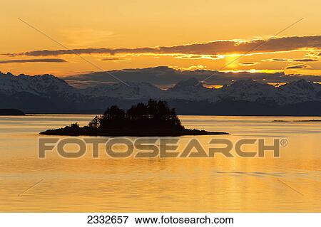 Sunset over favorite channel in inside passage with chilkat mountains and lynn canal in the distance; Alaska united states of america View Large Photo Image Stock Photo - Sunset over favorite channel in inside passage with chilkat mountains and lynn canal in the distance; Alaska united states of america. Fotosearch