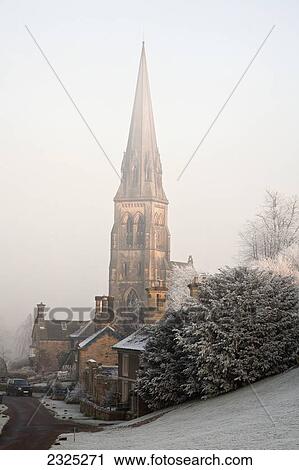 Stock Image - Tall steeple of a church in the fog on a frosty morning; Edendor derbyshire england. Fotosearch
