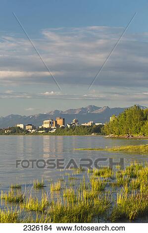 The anchorage city skyline seen from the tony knowles coastal trail during high tide chugach mountains in the background; Anchorage alaska united states of america View Large Photo Image Picture - The anchorage city skyline seen from the tony knowles coastal trail during high tide chugach mountains in the background; Anchorage alaska united states of america. Fotosearch