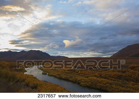 The Blackstone River Flows Through The Colourful Tundra At Sunset Along The Dempster Highway; Yukon Canada View Large Photo Image Stock Photo - The Blackstone River Flows Through The Colourful Tundra At Sunset Along The Dempster Highway; Yukon Canada. Fotosearch