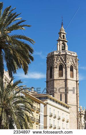 The miguelete the tower of the cathedral of valencia above palm trees and buildings of plaza de la reina; Valencia spain View Large Photo Image Stock Photo - The miguelete the tower of the cathedral of valencia above palm trees and buildings of plaza de la reina; Valencia spain. Fotosearch