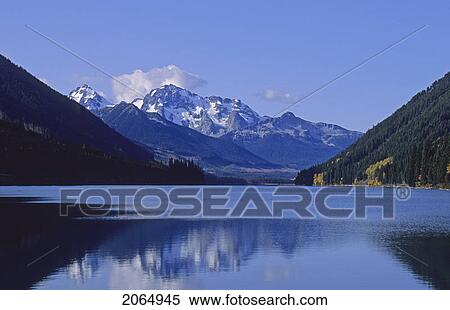Stock Photography - The Mountains Above Carpenter Lake Are Reflected In Early Winter, B. C.. Fotosearch