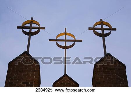 Stock Photography - Three crosses on church steeples against a blue sky; Calgary alberta canada. Fotosearch