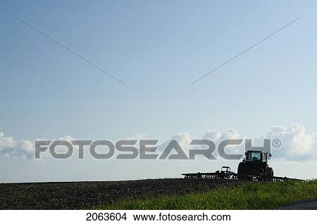 Picture - Tractor With Cultivator At The Edge Of A Field; Canada, Manitoba, Erickson. Fotosearch