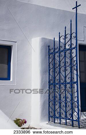 Stock Photograph - Traditional Santorini blue and white, an open gate with a cross; Imerovigli, Cyclades, Greece. Fotosearch