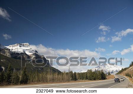 Vehicles on a highway with the canadian rocky mountains in banff national park; Alberta canada View Large Photo Image Stock Photo - Vehicles on a highway with the canadian rocky mountains in banff national park; Alberta canada. Fotosearch