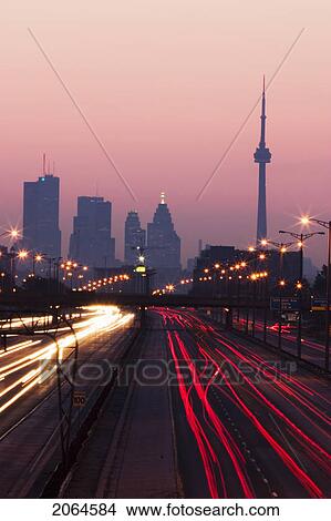 Picture - View Of Toronto Skyline From Above Queen Elizabeth Way Highway During Start Of Rush Hour Traffic, Toronto, Ontario, Canada.. Fotosearch