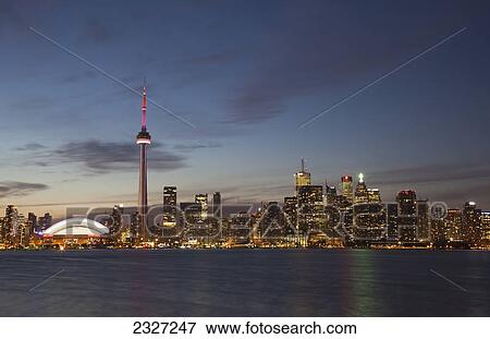 View over lake ontario of the downtown toronto skyline and cn tower illuminated at dusk; Toronto ontario canada View Large Photo Image Stock Photo - View over lake ontario of the downtown toronto skyline and cn tower illuminated at dusk; Toronto ontario canada. Fotosearch