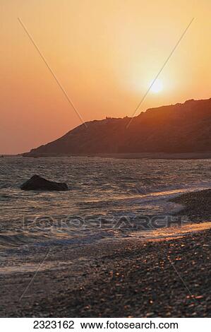 Waves coming into the shore and view of the coastline at sunset; Aphrodite bay cyprus View Large Photo Image Stock Image - Waves coming into the shore and view of the coastline at sunset; Aphrodite bay cyprus. Fotosearch