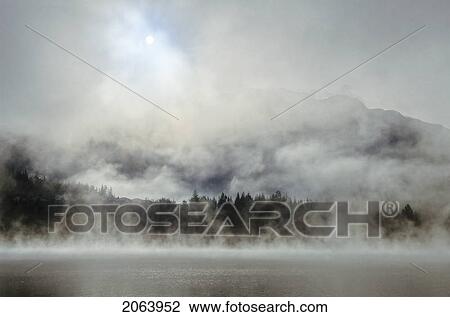 Stock Image - Whistler Mountain Rises Above Alta Lake On Misty Morning, Whistler, Bc Canada. Fotosearch