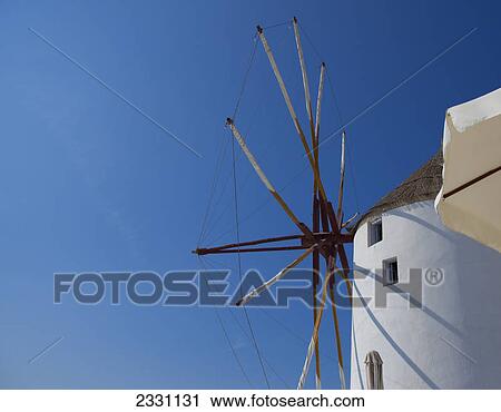 Windmill and a white building against a blue sky; Oia greece View Large Photo Image Stock Image - Windmill and a white building against a blue sky; Oia greece. Fotosearch