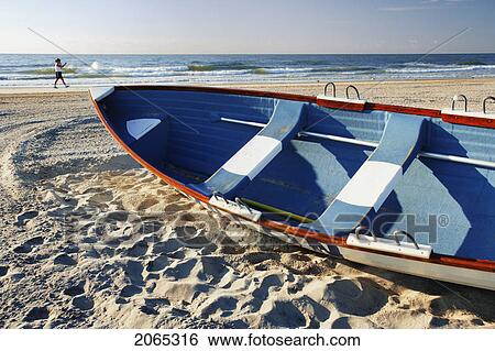 Woman Walking On Beach And Small Boat, New Jersy, Usa. View Large Photo Image Stock Photograph - Woman Walking On Beach And Small Boat, New Jersy, Usa.. Fotosearch
