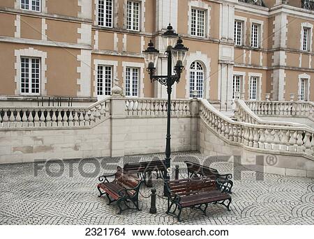 Picture - Wooden Benches Around A Lamp Post Outside Of A Building; Tokyo Japan. Fotosearch
