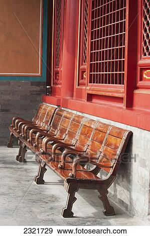 Stock Photo - Wooden Seating Against A Concrete And Red Wall; Forbidden City Beijing China. Fotosearch