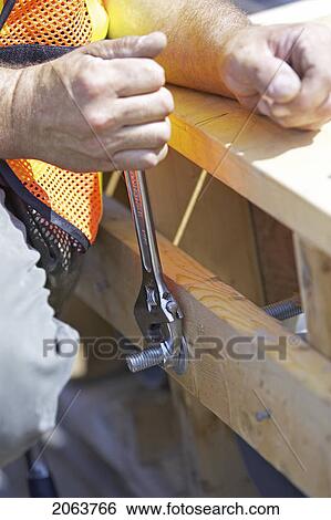 Stock Photograph - Worker Tightening A Bolt With A Wrench; Canada, Ontario, Hamilton (Composting Facility). Fotosearch
