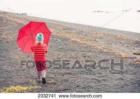 Young girl playing with her red umbrella while walking on the beach at Lowell Point on a rainy day, summer, Seward, Southcentral Alaska, USA View Large Photo Image Stock Image - Young girl playing with her red umbrella while walking on the beach at Lowell Point on a rainy day, summer, Seward, Southcentral Alaska, USA. Fotosearch