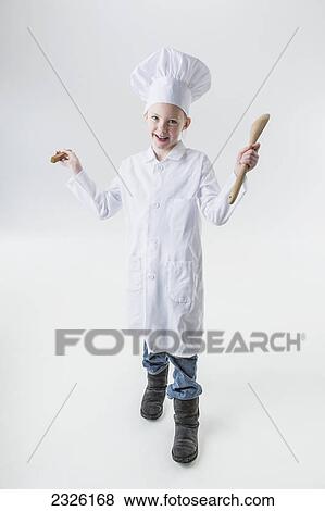 Young girl wearing a white chef's hat and apron and holding a wooden spoon; Anchorage alaska united states of america View Large Photo Image Stock Photo - Young girl wearing a white chef's hat and apron and holding a wooden spoon; Anchorage alaska united states of america. Fotosearch