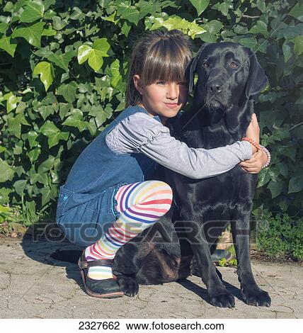 Stock Image - Young girl with her pet labrador; Malaga andalusia spain. Fotosearch