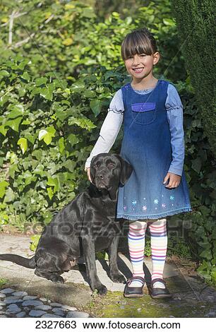 Stock Image - Young girl with her pet labrador; Malaga andalusia spain. Fotosearch