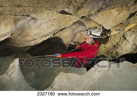 Young woman descending into an ice-plugged cave; Crowsnest pass alberta canada View Large Photo Image Stock Image - Young woman descending into an ice-plugged cave; Crowsnest pass alberta canada. Fotosearch