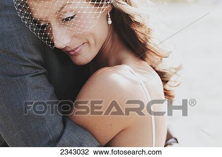 Stock Image - A bride and groom in an embrace; Kirkland, Washington, United States of America. Fotosearch