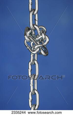Picture - A chain tied in a knot against a blue background. Fotosearch