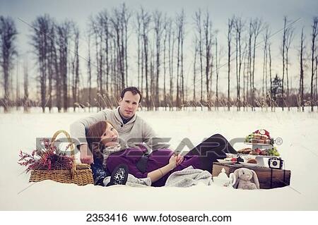 Stock Photograph - A couple having a winter picnic during pregnancy; Edmonton, Alberta, Canada. Fotosearch
