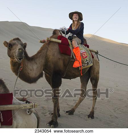A girl riding a camel; Jiuquan, Gansu, China View Large Photo Image Picture - A girl riding a camel; Jiuquan, Gansu, China. Fotosearch