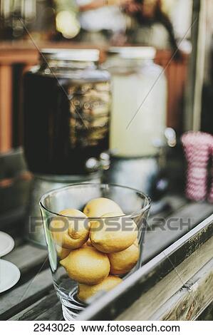A glass bowl filled with small lemons beside beverage containers; Pemberton, British Columbia, Canada View Large Photo Image Stock Photography - A glass bowl filled with small lemons beside beverage containers; Pemberton, British Columbia, Canada. Fotosearch