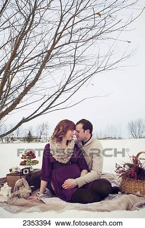 A husband and wife sitting in an embrace while having a winter picnic; Edmonton, Alberta, Canada View Large Photo Image Picture - A husband and wife sitting in an embrace while having a winter picnic; Edmonton, Alberta, Canada. Fotosearch