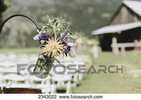 A jar of wildflowers hanging for decoration at an outdoor wedding ceremony; Pemberton, British Columbia, Canada View Large Photo Image Stock Image - A jar of wildflowers hanging for decoration at an outdoor wedding ceremony; Pemberton, British Columbia, Canada. Fotosearch