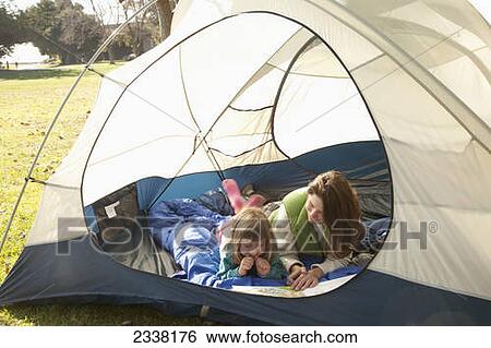 A mother and daughter lay in a tent reading a book; Crab Cove, Alemada, California, United States of America View Large Photo Image Stock Photograph - A mother and daughter lay in a tent reading a book; Crab Cove, Alemada, California, United States of America. Fotosearch