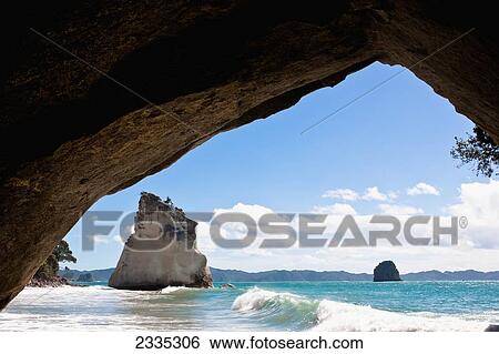 A natural rock arch and rock formations in the water on the coast; New Zealand View Large Photo Image Stock Photograph - A natural rock arch and rock formations in the water on the coast; New Zealand. Fotosearch